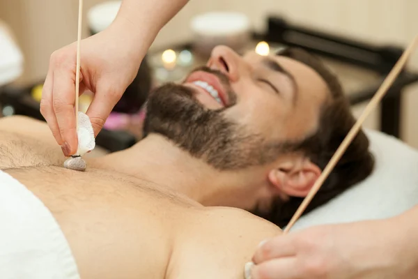 Attractive guy is getting massage at beauty salon — Stok fotoğraf