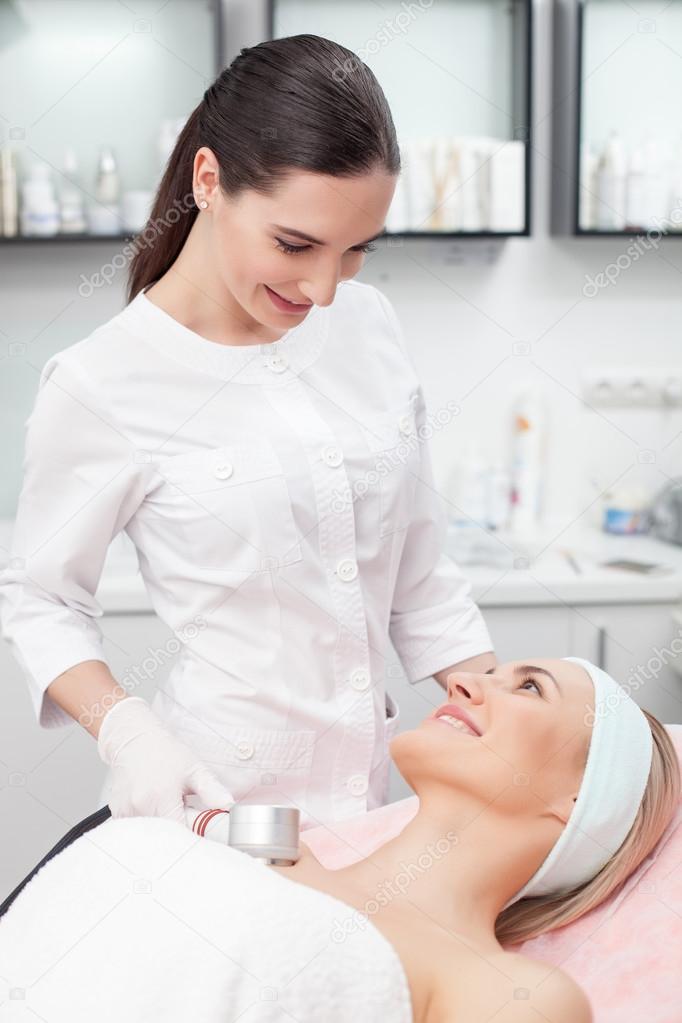 Attractive young beautician is treating her patient