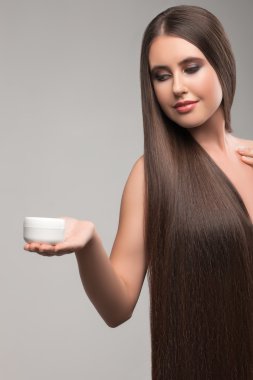 Attractive young woman is presenting beauty product