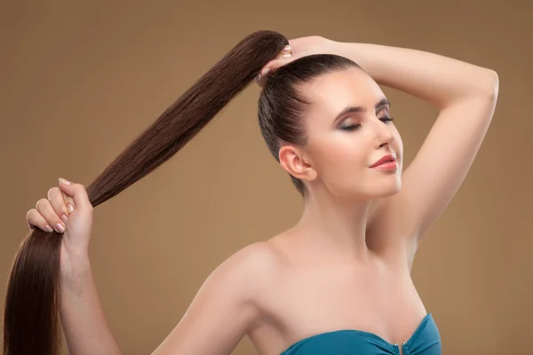 Beautiful young woman is showing her perfect hairstyle — Stockfoto