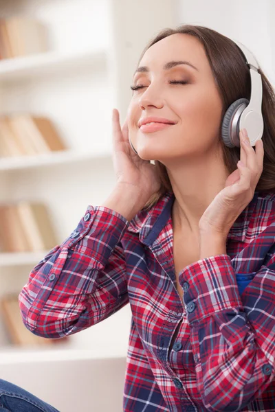 Chica atractiva es relajarse con auriculares en casa —  Fotos de Stock