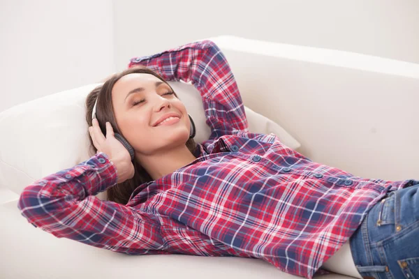 Jovem atraente está relaxando com fones de ouvido — Fotografia de Stock