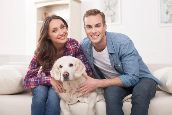 Pretty loving couple and puppy at home — Stock fotografie