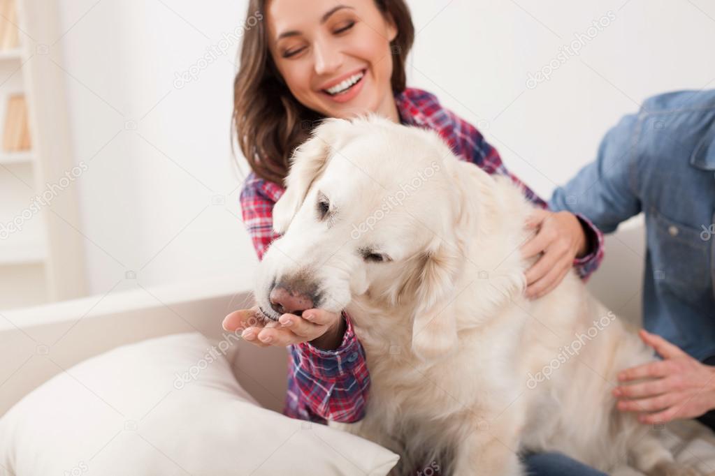 Cheerful husband and wife with pretty pet