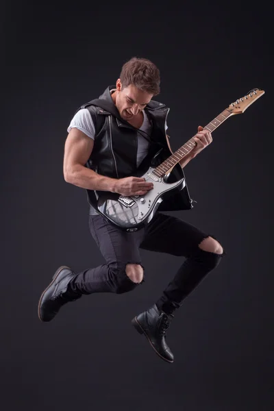 Attractive male guitarist with a cool musical instrument — Zdjęcie stockowe