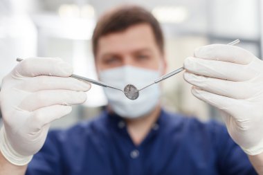 Handsome young dental doctor is preparing for work