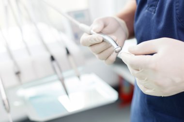 Experienced young dentist is working with medical tools