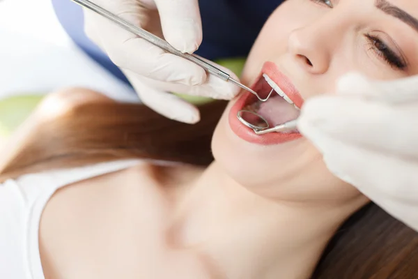 Dentista joven calificado está tratando la salud femenina — Foto de Stock