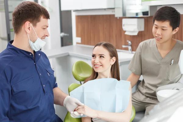 Guapo joven médico dental está apoyando a su paciente — Foto de Stock