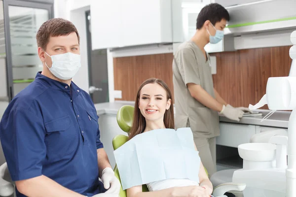 Bonito médico dentário em processo de tratamento de seu paciente — Fotografia de Stock