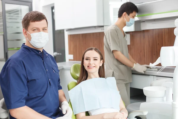 Guapo odontólogo en proceso de tratamiento de su paciente — Foto de Stock