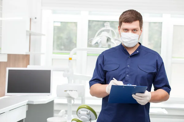 Atractivo joven dentista está trabajando en su gabinete — Foto de Stock