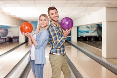 Cheerful two friends are making fun with kegling