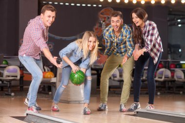 Cheerful friendly team is playing kegling together
