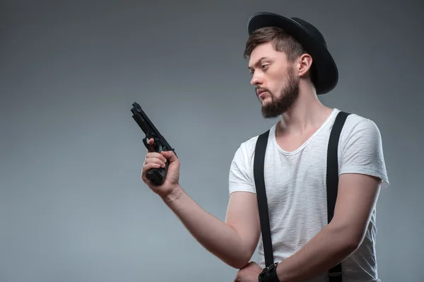 Fröhlicher junger Mann mit Waffe und Mütze — Stockfoto