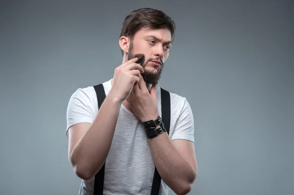 Attractive young strong man is shaving himself — Stock Photo, Image