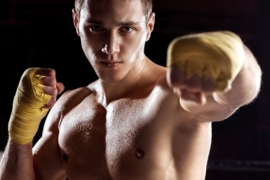 Handsome young boxer is fighting with effort