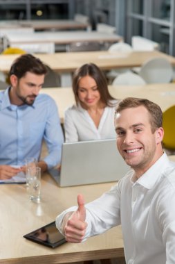 Cheerful young colleagues are discussing their job