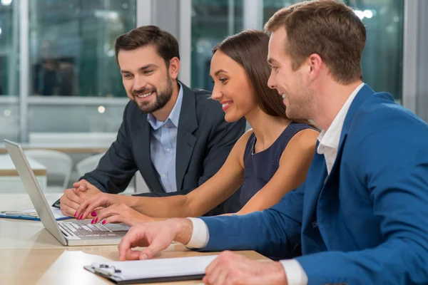 Atraktif tiga mitra bisnis berbicara di kantor — Stok Foto