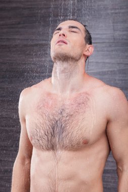 Cheerful male athlete is washing himself