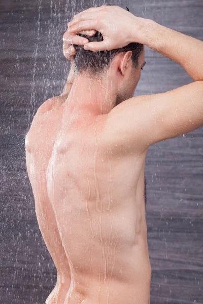 Jovem atraente está limpando seu corpo — Fotografia de Stock