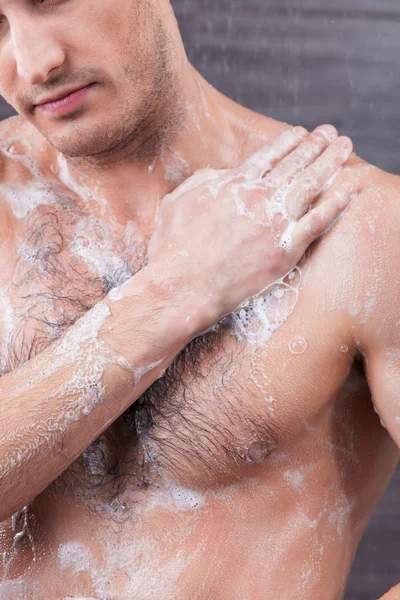 Attractive fit guy is taking a shower — Zdjęcie stockowe