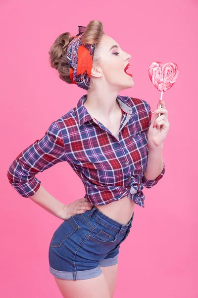 Linda chica pin-up está probando paleta dulce — Foto de Stock