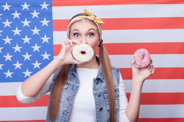 Cheerful young girl is eating American food — Stock Photo, Image