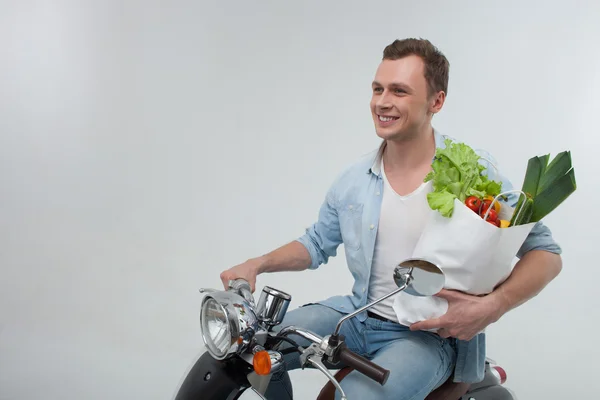 Schöner Kerl mit Bio-Produkten auf dem Motorrad — Stockfoto