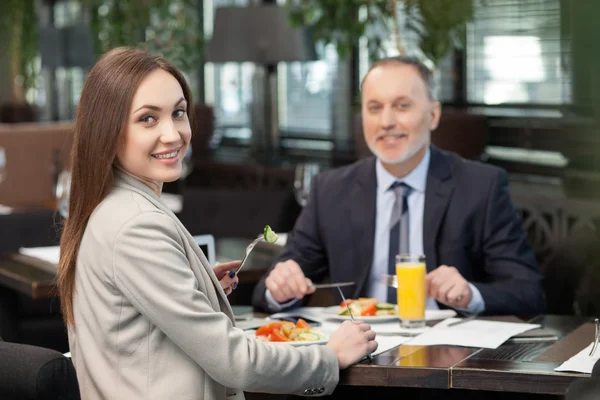 Cheerful colleagues have a business lunch in cafe — Stock Photo, Image