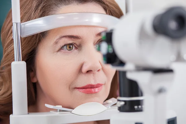 Fröhliche Dame bei Augenuntersuchung in Augenarztpraxis — Stockfoto