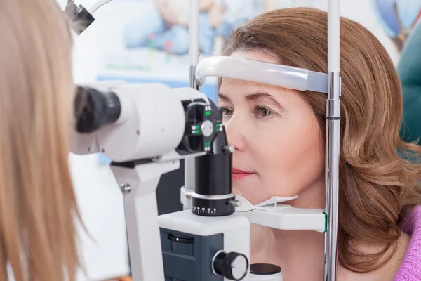 Женщина средних лет посещает глазного врача в клинике — стоковое фото