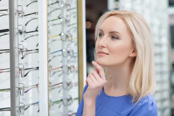 Attractive young lady is buying new spectacles — Stockfoto