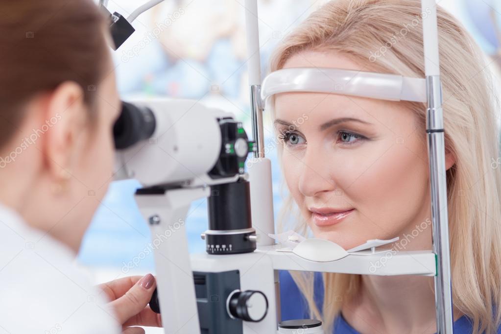 Professional oculist is checking human vision with equipment