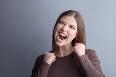 Cheerful young woman is expressing positive emotions