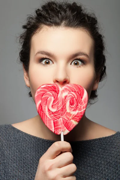Beautiful young girl with tasty sweet lollipop — Zdjęcie stockowe