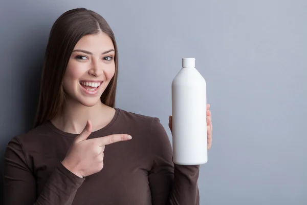 Cheerful young woman is advertising care product
