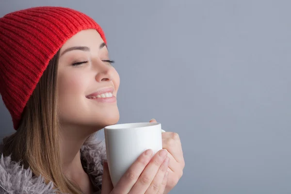 Приваблива молода жінка насолоджується гарячим чаєм — стокове фото