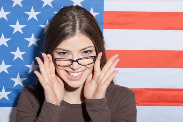 Mujer alegre inteligente cerca de la bandera de EE.UU. — Foto de Stock