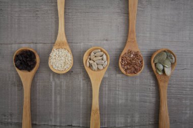 Tahta kaşıklarda tohumlar Gri ahşap arka planda