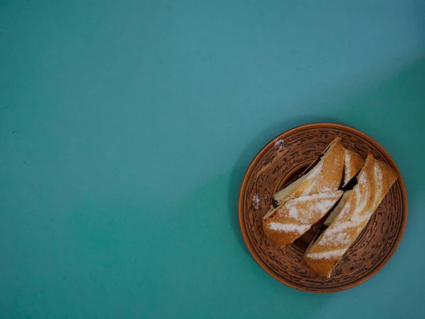 Antike handgefertigte Steingutplatte mit Birkenrinde verziert mit Scheiben köstlicher Vogelkirschtorte auf grünem Hintergrund mit Kopierraum — Stockfoto