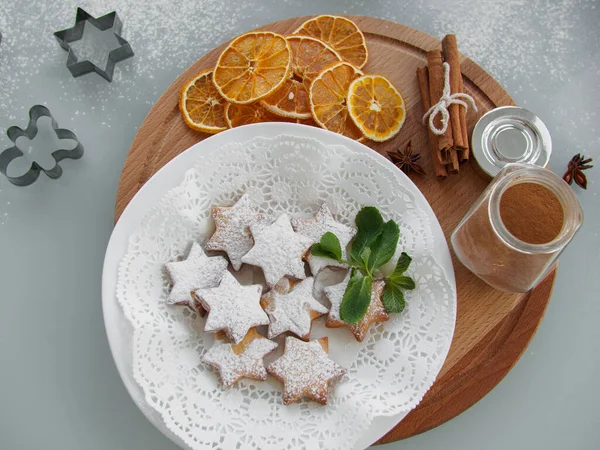 Flache Lage aus sternförmigen Lebkuchen, verziert mit Puderzucker und Minze auf Holzblech, von oben — Stockfoto