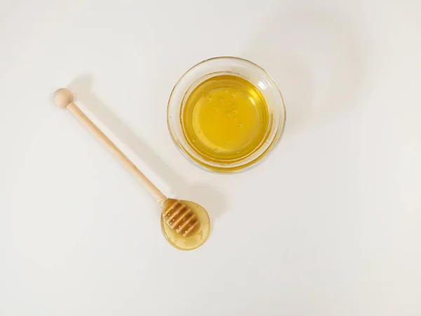 Honiglöffel und Schale mit goldenem süßem Honig auf weißem Hintergrund. Flache Lage, Draufsicht — Stockfoto