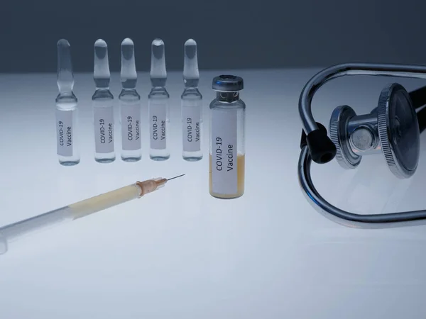 Ampolas e um frasco para injetáveis com uma vacina para injeção na mesa. Vacinação contra o coronavírus — Fotografia de Stock