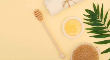 Rahatlama ve kilo kaybı için spa tedavisi pankartları. Doğal bal, bal kapağı, kuru vücut masajı fırçası, sarı arka planda beyaz havlu. Boşluğu kopyala, düz yat, üst görünüm