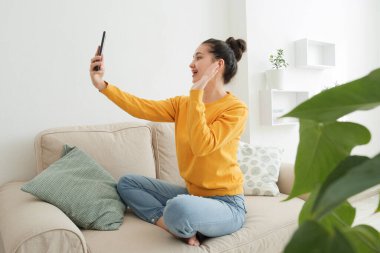 Blogcu blogundan canlı yayın yapıyor. Kadın takipçilerini selamlıyor.