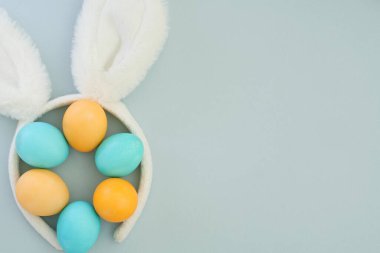 Minimalist tarzda Paskalya kompozisyonu, paskalya pastel yumurtaları ve mavi arka planda tavşan kulakları. Estetik, güzellik, mutlu paskalyalar. Boşluğu kopyala, üst görünüm, düz uzanma
