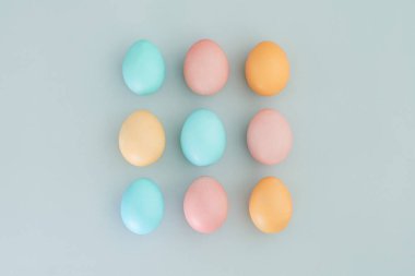 Mavi arka planda çok renkli pastel Paskalya yumurtaları. Üst manzara, düz uzanma