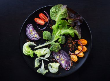 Siyah bir tabakta sebze taze salata