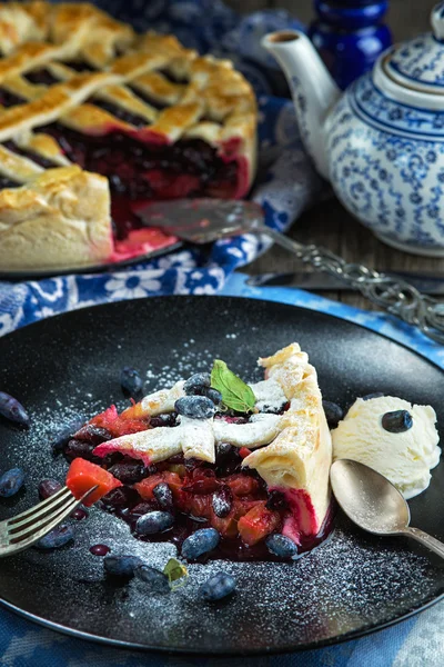 Beerenkuchen auf gedecktem Tisch und Teekanne — Stockfoto